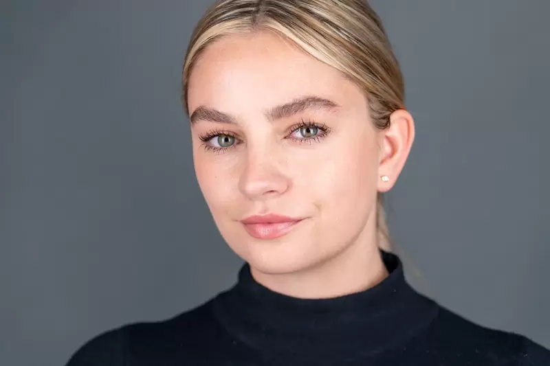 Studio style actor headshot of a woman on a grey background