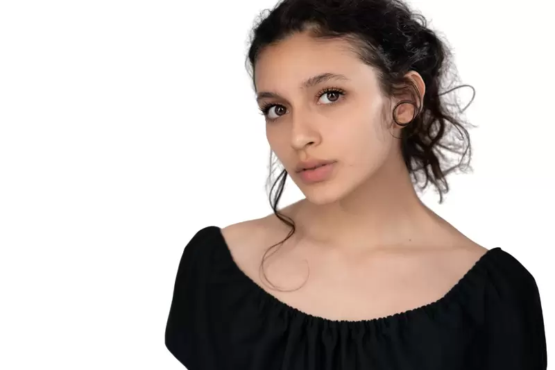 Actor headshot of a woman with curly hair on a white background