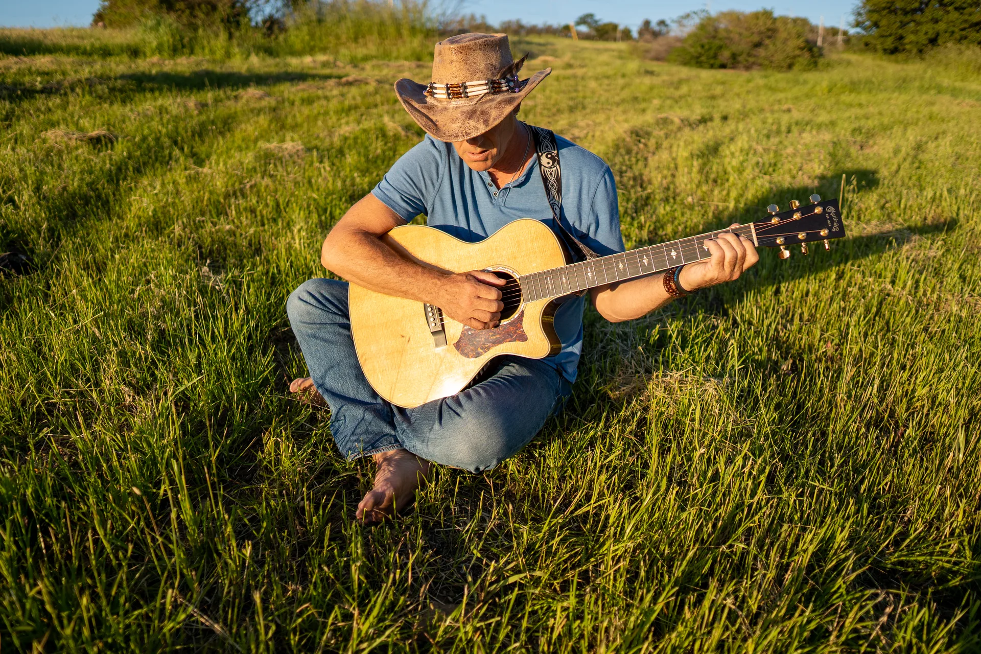 Portrait of a guitarist wearing a hat during an outdoor session