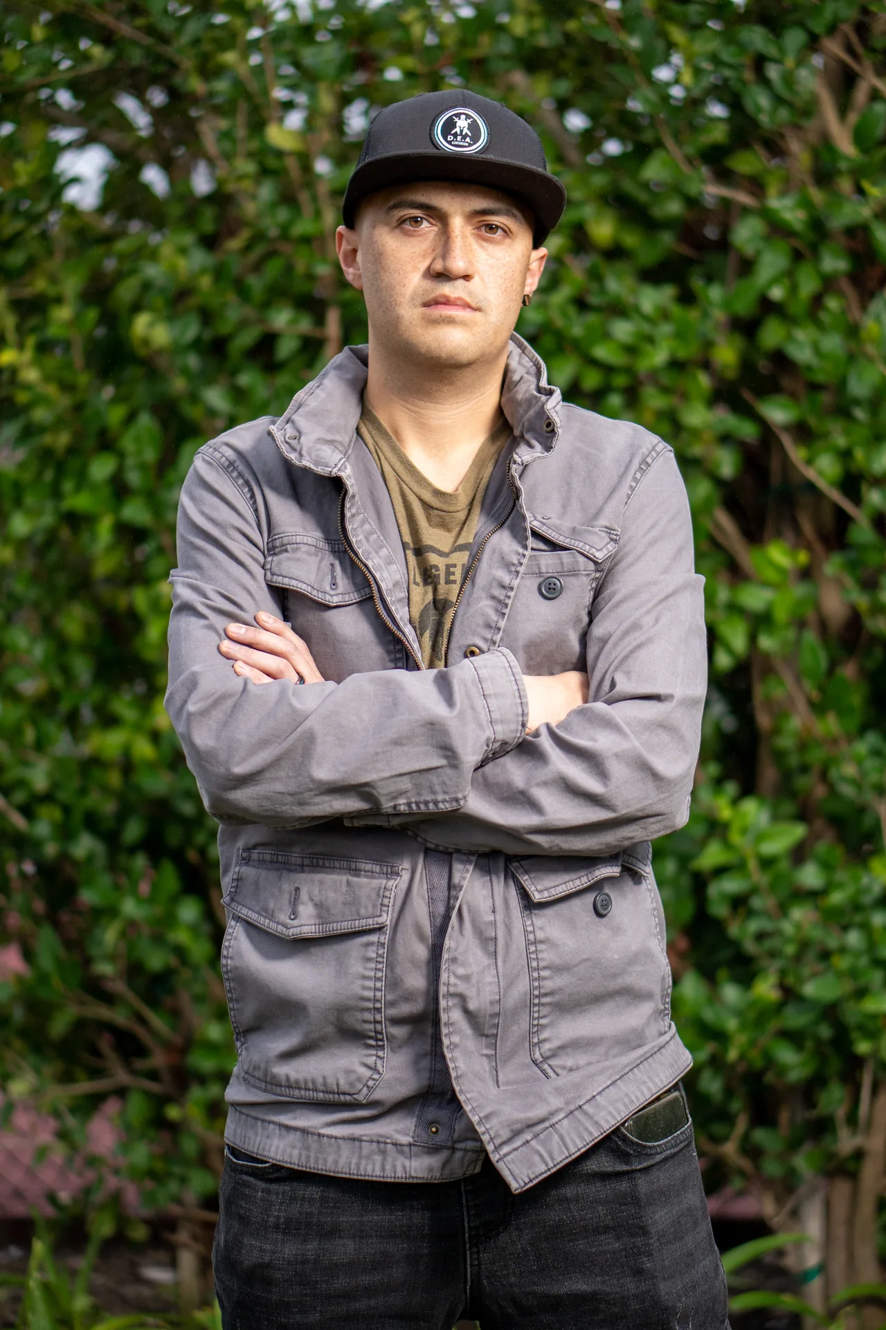 Confident professional headshot with arms crossed on a grey background