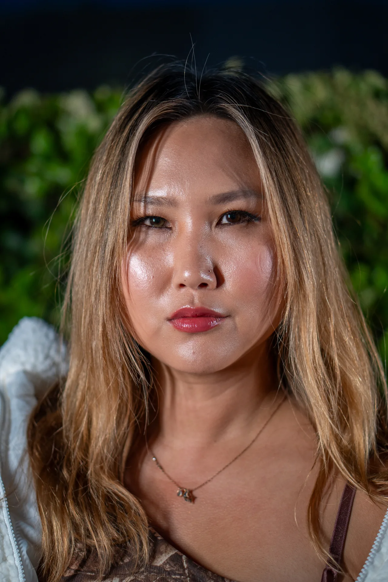 Professional headshot of a woman photographed on a dark background